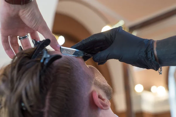 Frisören Rakar Ung Skäggig Frisersalongskund Med Rakhyvel Nära Håll Skäggklippning — Stockfoto