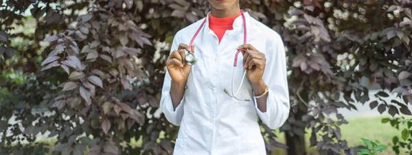 Mão de close-up de médica afro-americana com membrana auscultatória do fonendoscópio. Conceito médico. Mulher médica preta de casaco branco com fonendoscópio — Fotografia de Stock