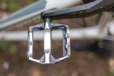 Arka planda yapay çim olan bisiklet pedalı. yakın çekimli bisiklet pedalı üst görünümü, kullanımda