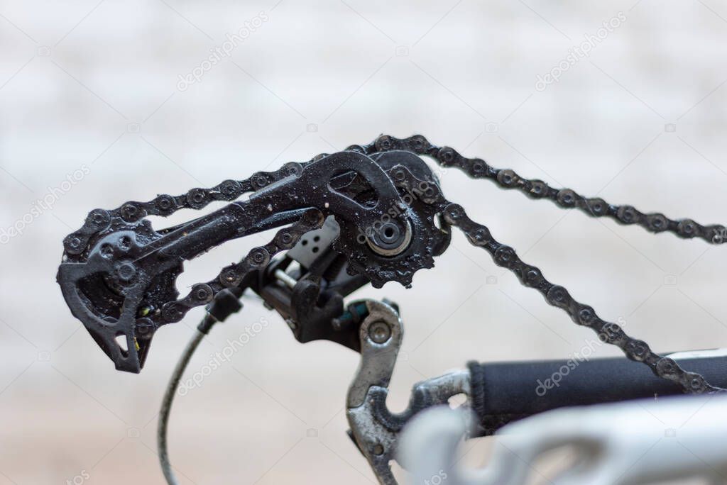 the rear derailleur of the bike is broken, no wheel. close-up, on a white background Closeup of rear derailleur - idler lower pully