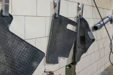 Kirli araba paspasları temizlikten önce sallanıyor