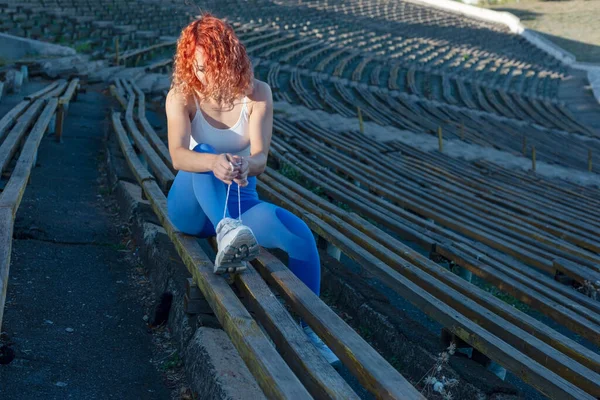 Kızıl Saçlı Sporcu Kadın Otuz Altı Yaşında Bir Bankta Oturuyor — Stok fotoğraf