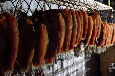 Tütsülenmiş balık leşleri soğuk füme balığın üzerinde sigara içtikten sonra art arda yetiştirilir. Gıda endüstrisi.