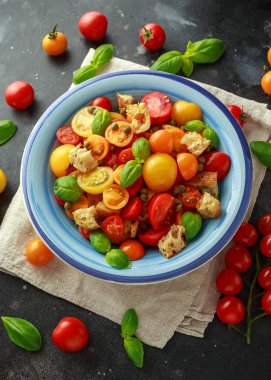 Kırmızı, sarı, turuncu kiraz domates, kapari, fesleğen ve ciabatta Panzanella domates salatası kruton. Yaz sağlıklı gıda.
