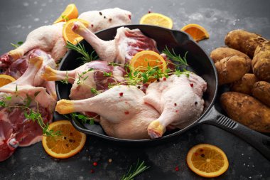 Biber, portakal ve dökme demir tavada otlar ile terbiyeli ücretsiz aralığı ördek bacaklar ile organik patates hizmet.