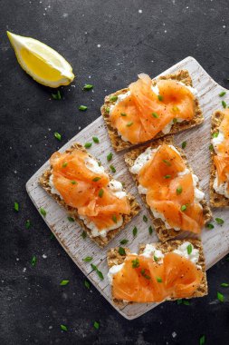 Somon füme ve yumuşak peynir, beyaz tahta üzerinde chives ile ev yapımı Crispbread ekmeği