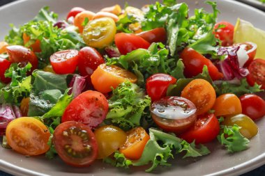 Taze kiraz domates karışımı salata marul, limon, limon, karabiber ve deniz tuzu. sağlıklı gıda