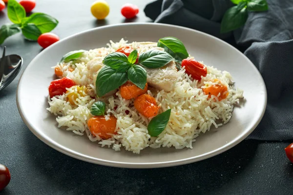 Buğulanmış morina balığı pirinç ve kiraz domates ve fesleğen otlar bir tabak içinde karıştırın