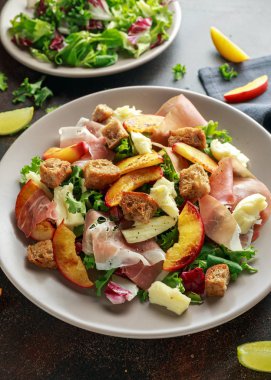 Taze ızgara şeftali salatası yeşil karışımı, peynir, jambon ve kızarmış ekmek parçaları ile