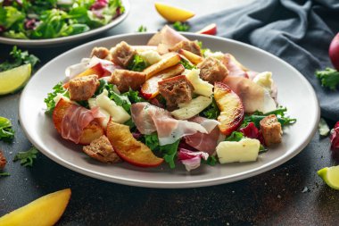 Taze ızgara şeftali salatası yeşil karışımı, peynir, jambon ve kızarmış ekmek parçaları ile