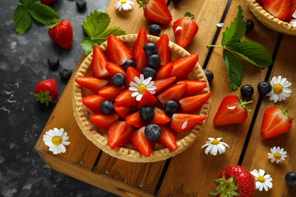 Nybakade Strawberry vaniljsås tårtor på träbricka med camomiles, sommar — Stockfoto