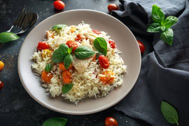 Buğulanmış morina balığı pirinç ve kiraz domates ve fesleğen otlar bir tabak içinde karıştırın