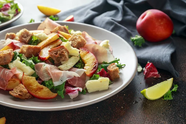 Taze ızgara şeftali salatası yeşil karışımı, peynir, jambon ve kızarmış ekmek parçaları ile