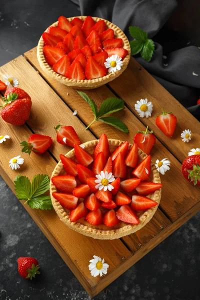 Nybakade Strawberry vaniljsås tårtor på träbricka med camomiles, sommar — Stockfoto