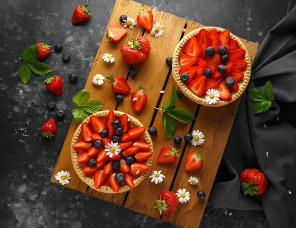 Tartas de natillas de fresa recién horneadas en bandeja de madera con manzanillas, tema de verano —  Fotos de Stock