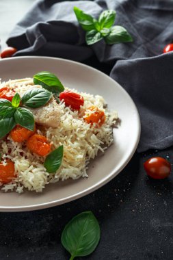 Buğulanmış morina balığı pirinç ve kiraz domates ve fesleğen otlar bir tabak içinde karıştırın