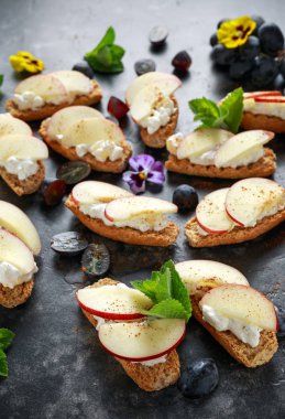 Sağlıklı kahvaltı tost süzme peynir ve tarçın ile serpilir Kuru soğan dilimleri ile servis karanlık üzüm ve yenilebilir çiçekler