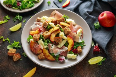 Taze ızgara şeftali salatası yeşil karışımı, peynir, jambon ve kızarmış ekmek parçaları ile