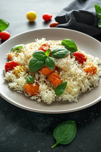 Buğulanmış morina balığı pirinç ve kiraz domates ve fesleğen otlar bir tabak içinde karıştırın