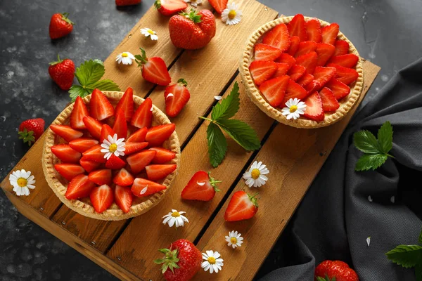 Tartes à la crème aux fraises fraîchement cuites sur plateau en bois avec camomilles, thème d'été — Photo