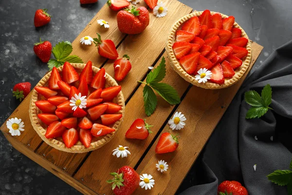 Nybakade Strawberry vaniljsås tårtor på träbricka med camomiles, sommar — Stockfoto