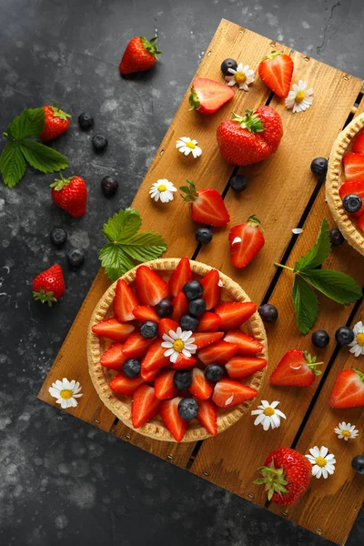 Tartas de natillas de fresa recién horneadas en bandeja de madera con manzanillas, tema de verano —  Fotos de Stock