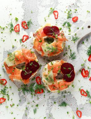 Füme somon simit tost peyniri, salatalık şeritler ve pancar ve dereotu, tere salatası ile