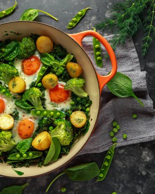 Bir Pan yeşil shakshuka lahana, brokoli, bezelye, ıspanak ve dereotu ile ücretsiz aralığı yumurta ile yemek mükemmel.
