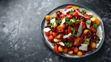 Healthy Red beans and mix of organic red and yellow pear shaped, beef heart and cherry tomatoes salad with picorino romano cheese shavings topped with parsley clipart