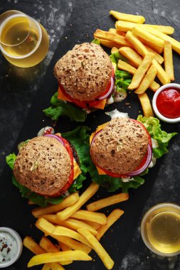 sığır eti burger marul, Yunan yoğurt sosu, biftek domates, kırmızı soğan halkaları ve eritilmiş peynir rustik bir sayaçta patates kızartması ile servis ızgara