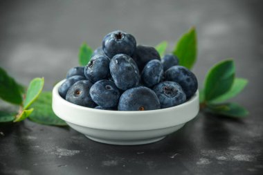 Taze yaban mersini yeşil yaprakları ile beyaz kase aldı. sağlıklı gıda