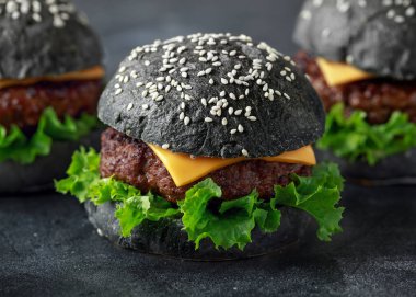 Peynir, et ve yeşil salata ile siyah Burger bırakıyor. Ev yapımı çizburger