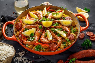 Kızartma tavada tavuk, karides, baharatlı chorizo, limon ve beyaz şarap ile geleneksel paella.