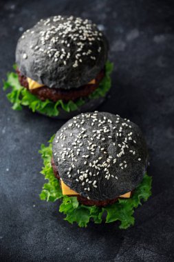 Peynir, et ve yeşil salata ile siyah Burger bırakıyor. Ev yapımı çizburger