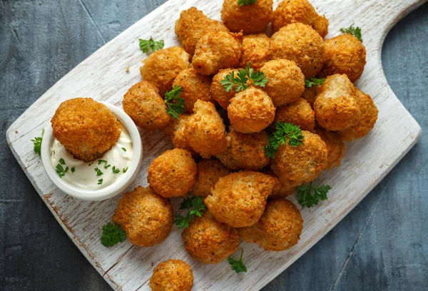 Homemade Breaded Garlic Mushrooms with sour cream and parsley on white wooden board — Stock Photo, Image