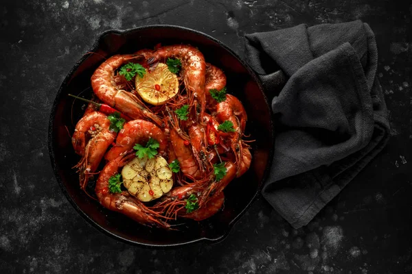 Tiger prawns fried in butter with, lemon juice, garlic and white wine served in cast iron skillet with parsley