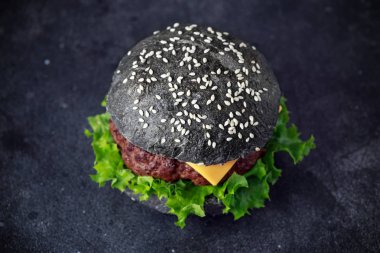 Peynir, et ve yeşil salata ile siyah Burger bırakıyor. Ev yapımı çizburger