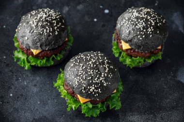 Peynir, et ve yeşil salata ile siyah Burger bırakıyor. Ev yapımı çizburger