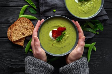 Kazak, kazak soğuk havalarda ısınma rahat tutarak ellerinde. Tatlı bezelye, pırasa ve nane sıcak çorba gevrek domuz pastırması ve dolop yoğurt ile tepesinde
