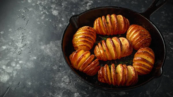 Hasselback sült burgonyával tálalva öntöttvas serpenyőben sóval, borssal, gyógynövények — Stock Fotó