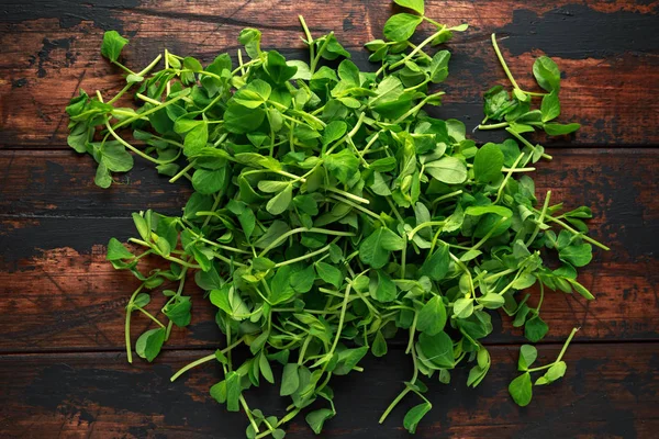 Dulces brotes de guisante verde crudo sobre fondo rústico de madera —  Fotos de Stock