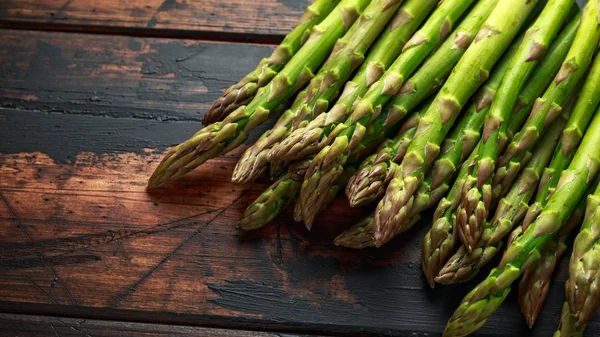 Fresh raw green asparagus on rustic wooden background — Stock Photo, Image