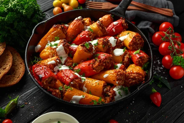 Carne de salchicha, carne picada y arroz Mini pimientos dulces rellenos horneados en sartén de hierro fundido, sartén cubierta con yogur y perejil fresco — Foto de Stock