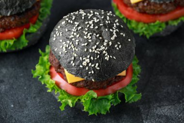 Peynir, Dana eti, domates ve yeşil salata ile siyah Burger bırakıyor. Ev yapımı çizburger