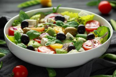 Sağlıklı düşük kalori salata marul, domates, avokado, beyaz peynir, kırmızı soğan, salatalık, tatlı bezelye, zeytin, kekik, nane ve fesleğen ile.