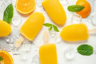 Çubuklu dondurmayı, çubuk üzerinde buz lollies buz beyaz zemin üzerine tatlı portakal suyu ile.