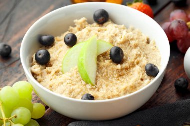 Sağlıklı kahvaltı aotmeal ile yaban mersini ve yeşil elma beyaz kase