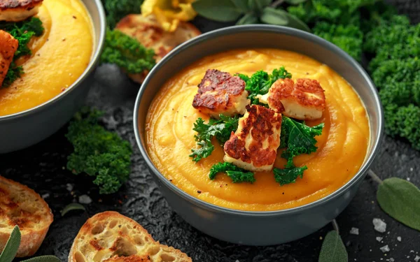 Baked butternut squash and carrot cream soup with steamed kale and fried halluomi.