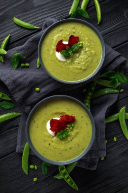 Tatlı bezelye, pırasa ve nane sıcak çorba gevrek domuz pastırması ve dolop yoğurt ile tepesinde
