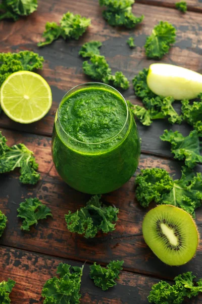 Batidos verdes con col rizada, kiwi, manzana y lima sobre mesa de madera —  Fotos de Stock